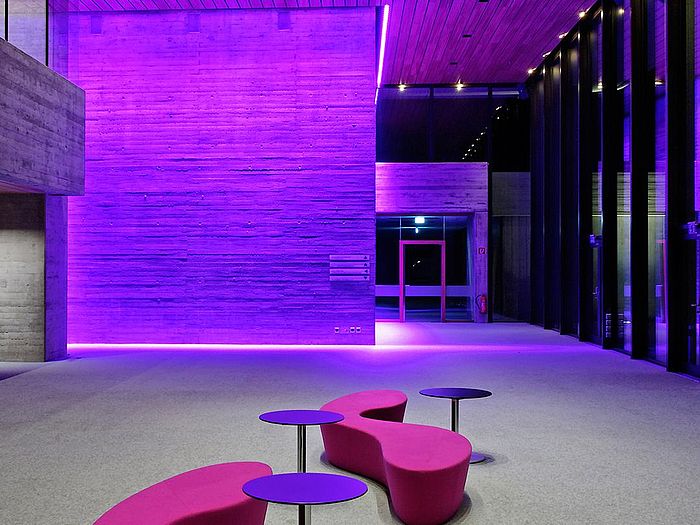 Pinke LED-Beleuchtung der Sichtbetonwände mit pinken Lounge Möbeln in der Klassik Radio Lounge